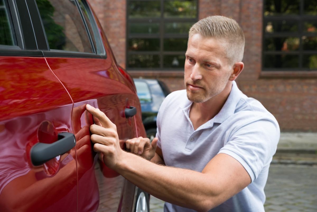 Checking car door for damage,